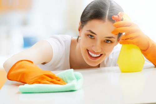 Cleaner preparing kitchen cupboards during a move in clean